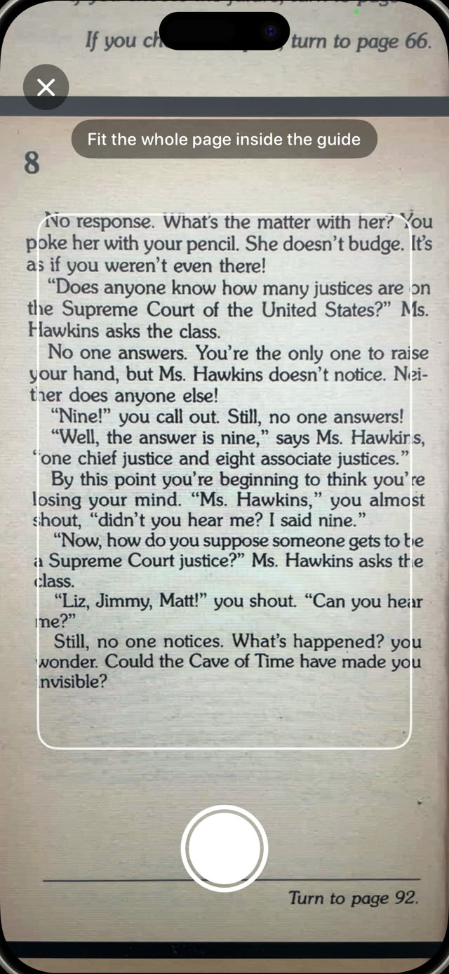 Child scanning a page of a printed book with the Guardian Reader camera and its framing guide